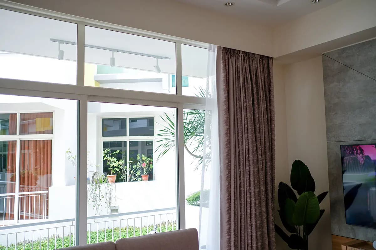Layered custom curtains installed across a living-room window